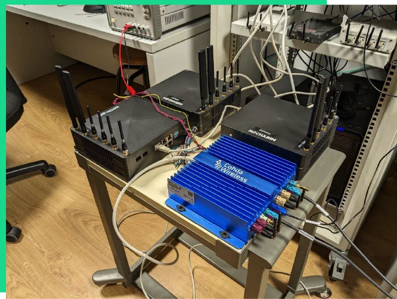 Cohda Wireless MK6 unit and RSU/OBU-capable devices on a lab table